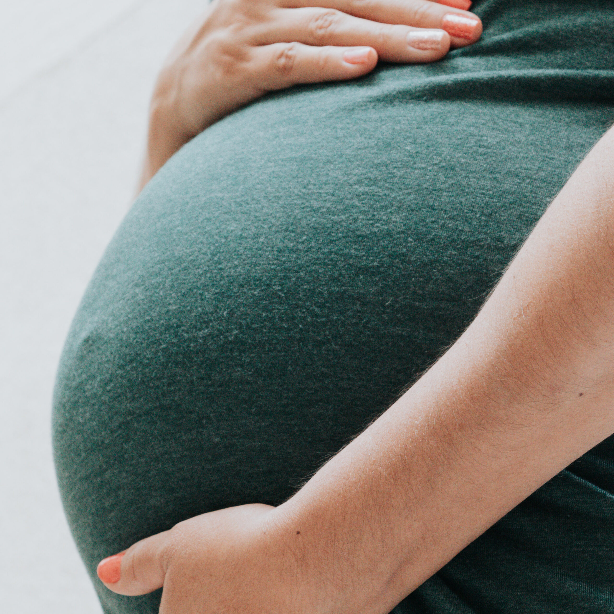 woman hugging her pregnanat belly, family, inherited family trauma